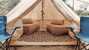 tenda con 2 sedie e un letto. di Rustika Glamping a Kampong Tanjong Che Lahom Altre 6 foto