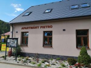 a building with a sign that reads patriarchy tattoo at APARTMÁNY PIETRO in Oravský Podzámok