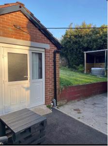 a brick building with a white door and a bench at Belfast Macs double room shared bathroom in Belfast +4 photos