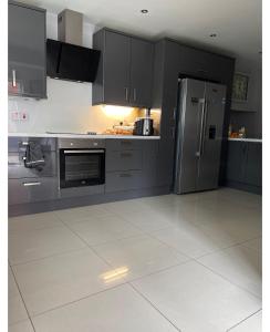 a kitchen with black cabinets and a stainless steel refrigerator at Mac’s in Belfast