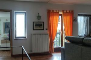 uma sala de estar com cortinas cor de laranja e um sofá em Casa Camino em Rubiana