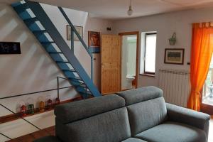 ein Wohnzimmer mit einem Sofa und einer Treppe in der Unterkunft Casa Camino in Rubiana