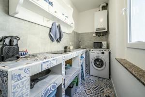 una piccola cucina con piastrelle bianche e blu di Le Finestre sul Borgo 2 a Parma