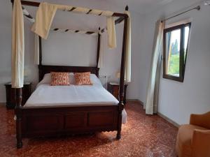 1 dormitorio con cama con dosel y ventana en Agroturismo Finca Son Amora, en Palma de Mallorca