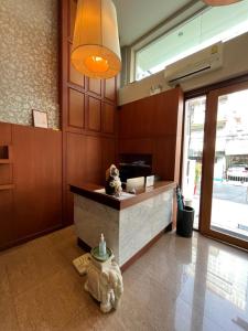 a lobby with a counter with two teddy bears sitting at it at Jhouse Thonglor in Khlong Toei +6 photos