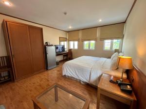 a bedroom with a bed and a table with a table at Jhouse Thonglor in Klong Toi