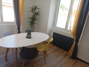 a dining room with a white table and chairs at Appartement centre de Sisteron in Sisteron