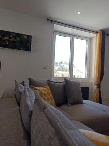a couch in a living room with two windows at Appartement centre de Sisteron in Sisteron