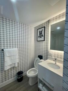 a bathroom with a toilet and a sink and a mirror at Superior Shores Hotel BW Signature Collection in Thunder Bay