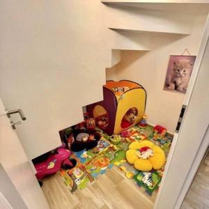 een speelkamer voor kinderen met speelgoed op de vloer bij LILIBORI apartman in Pápa