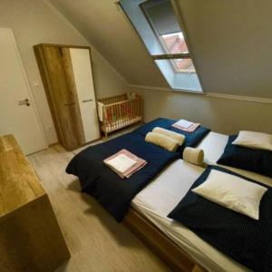 een slaapkamer met een groot bed met blauwe lakens en een raam bij LILIBORI apartman in Pápa