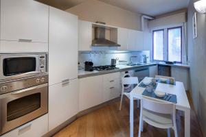 una cucina con armadi bianchi e tavolo con sedie di Beautiful house with lovely sea view terrace a Camogli