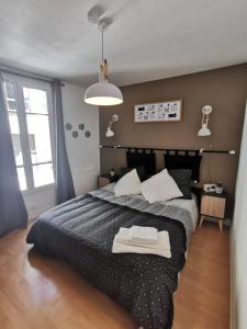 una camera da letto con un letto con un piumone nero di LE COSY - Appartement Pontoise Cosy Calme a Pontoise