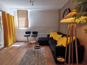 un soggiorno con divano nero e sedie di LE COSY - Appartement Pontoise Cosy Calme a Pontoise