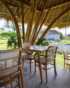 a wooden table and chairs on a patio at Nadi Nature Resort - Adults Only in Tabanan