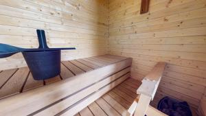 a wooden sauna with a bucket and a bench at Starvillas B 202 Sisältää loppusiivouksen in Kalajoki