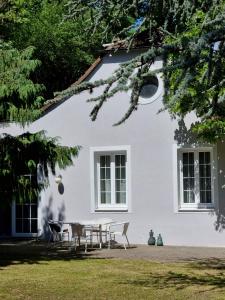ein weißes Haus mit einem Tisch und Stühlen in der Unterkunft Altes Zollhaus in Höflein an der Donau