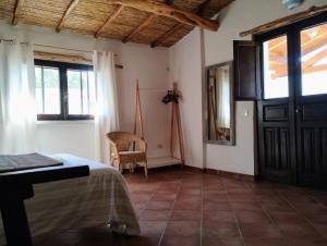 1 dormitorio con cama, ventana y puerta en La Casetta, en Padru