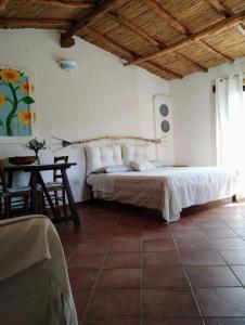una camera con un grande letto e un tavolo di La Casetta a Padru