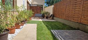 een tuin met potplanten en een hek bij CinemApartman Eger in Eger