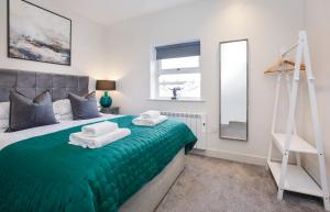 a bedroom with a green bed with towels on it at York Luxury Apartments, Bishopthorpe Rd in York