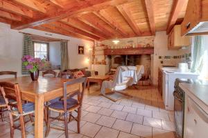a kitchen and dining room with a wooden ceiling at Location À 5mn De Saint Lary in Sailhan