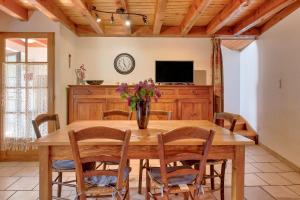 a dining room with a table and chairs and a tv at Location À 5mn De Saint Lary in Sailhan