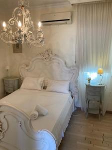 a bedroom with a large white bed and a chandelier at Anna Villa in Protaras