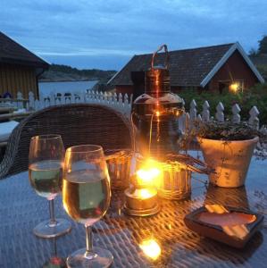 a table with wine glasses and a bottle and lights at Lunvig Romantic country house by the sea in Kristiansand, Søgne in Kristiansand