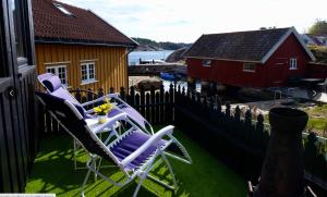 un grupo de sillas sentadas en un balcón con una casa en Lunvig Romantic country house by the sea in Kristiansand, Søgne, en Kristiansand