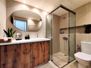 a bathroom with a shower and a sink and a mirror at Spiti Sea View Neoclassical House in Stenies in Andros