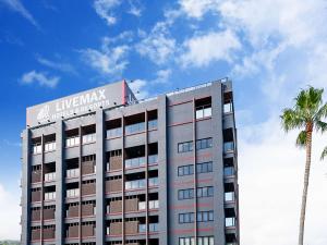 a building with a sign on top of it with a palm tree at LiVEMAX RESORT Atami Sea Front in Atami