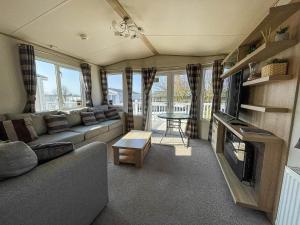 a living room with a couch and a fire place at 6 Berth Caravan At California Cliffs With Decking In Scratby Ref 50015kc in Great Yarmouth
