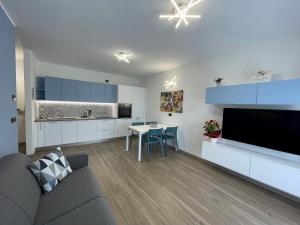 una cucina e un soggiorno con divano e tavolo di Appartamento La Baita Case Sondrio Fiume - Affitti Brevi Italia a Sondrio