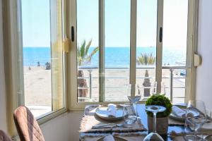 a dining room with a table with a view of the beach at Wave Beachfront Apartments in Durrës