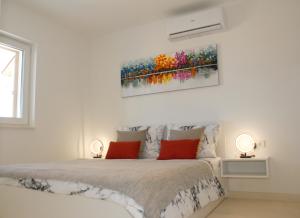 een witte slaapkamer met een bed met twee lampen aan beide zijden bij Villa Nonna in Vodice +40 foto's