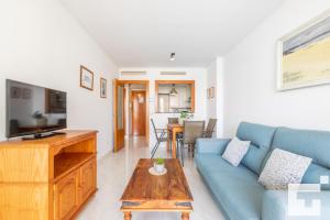 sala de estar con sofá azul y mesa en Apartamento Mesana 13 - Grupo Turis, en Calpe