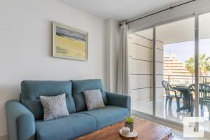 a living room with a blue couch and a table at Apartamento Mesana 13 - Grupo Turis in Calpe