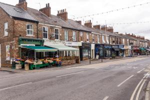 a street with buildings and shops on the side of the road at York Luxury Apartments, Bishopthorpe Rd in York