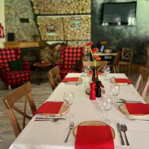 レスコにあるChaty Lesko-Skiの赤いナプキンとワイングラスを用意したレストランのテーブル