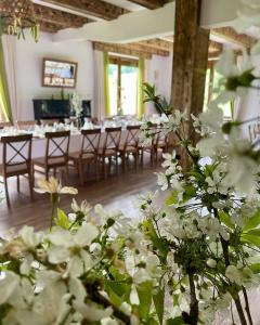 Cette chambre comprend des tables, des chaises et des fleurs blanches. dans l'établissement Chaty Lesko-Ski, à Lesko