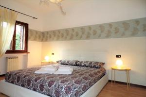 a bedroom with a large bed with two tables at Villetta Mazzini Front Lake - Happy Rentals in Peschiera del Garda