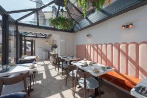 a row of tables in a room with windows at Somerset House Boutique Hotel and Restaurant in Portsmouth