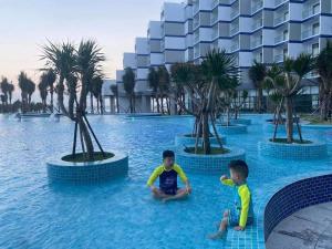 twee jonge jongens in het water in een resort bij Arena Cam Ranh Beach resort in Miếu Ông