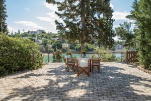 einen Tisch und Stühle auf einer Backsteinterrasse mit Aussicht in der Unterkunft Grand Bleu Porto Heli - Beachfront House, Agios Emilianos in Porto Heli