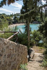un sentiero che conduce a una spiaggia con un bacino d'acqua di Grand Bleu Porto Heli - Beachfront House, Agios Emilianos a Porto Heli