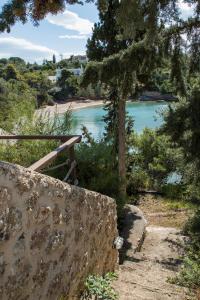 un sentiero che conduce a una spiaggia con uno specchio d'acqua di Grand Bleu Porto Heli Beachfront House a Porto Heli Altre 12 foto