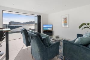 uma sala de estar com duas cadeiras e uma mesa em Estuary View, 3 Grand Banks em Teignmouth