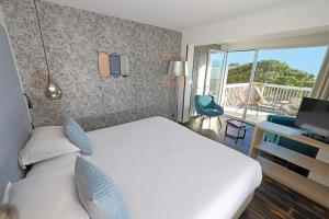 um quarto de hotel com uma cama e uma varanda em Hotel Onda em Calvi