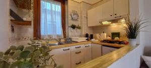 eine Küche mit weißen Schränken, einem Waschbecken und einem Fenster in der Unterkunft Alloggio turistico a Via Modugno in Vitinia